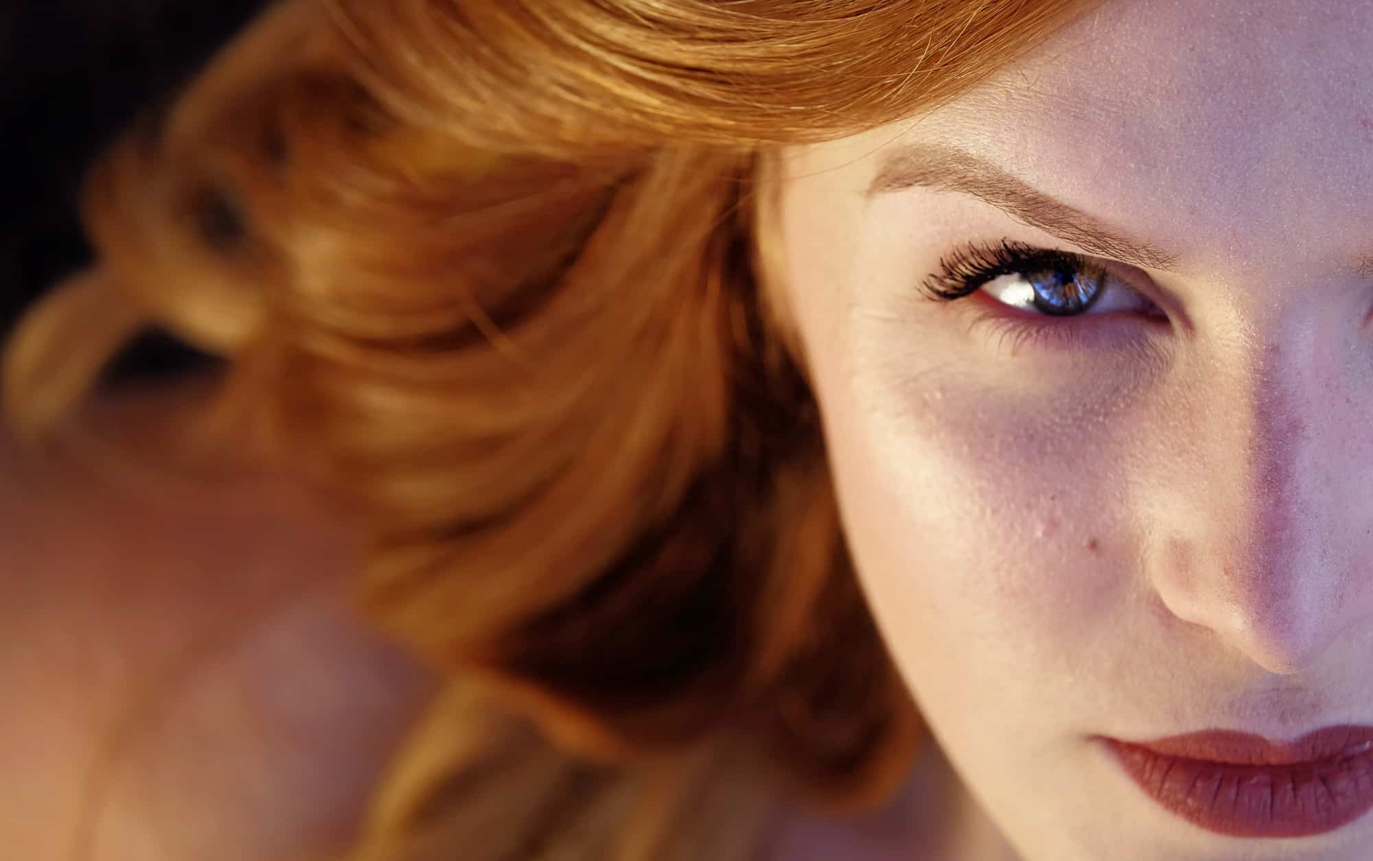 Woman with ginger hair staring enigmatically at camera