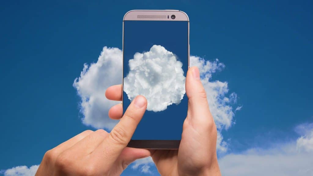 Mobile phone being held up to the sky with image of cloud on screen