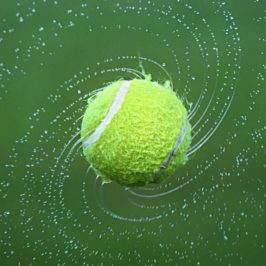Spinning tennis ball, dispersing water droplets