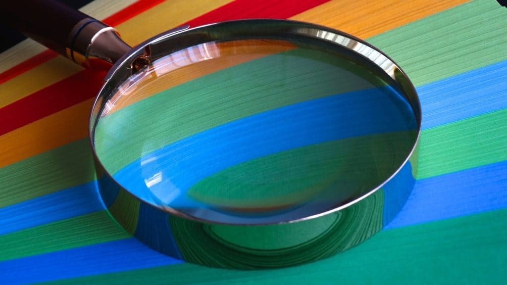 Magnifying glass lying on coloured paper