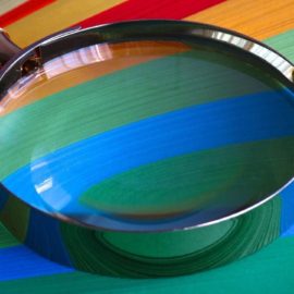 Magnifying glass lying on coloured paper