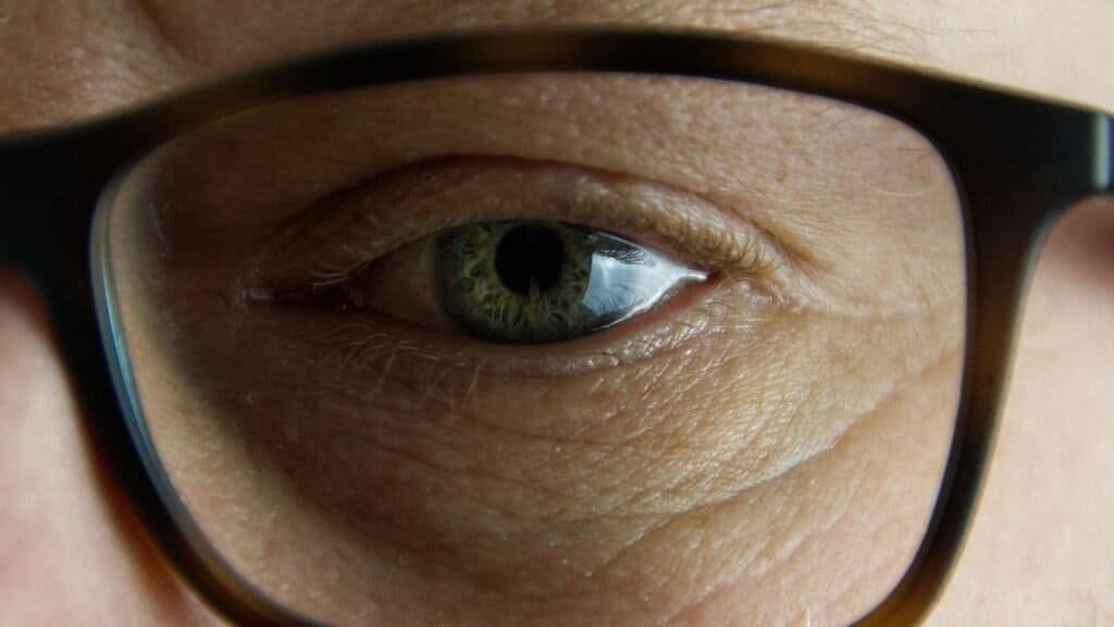 A man's eye behind glasses